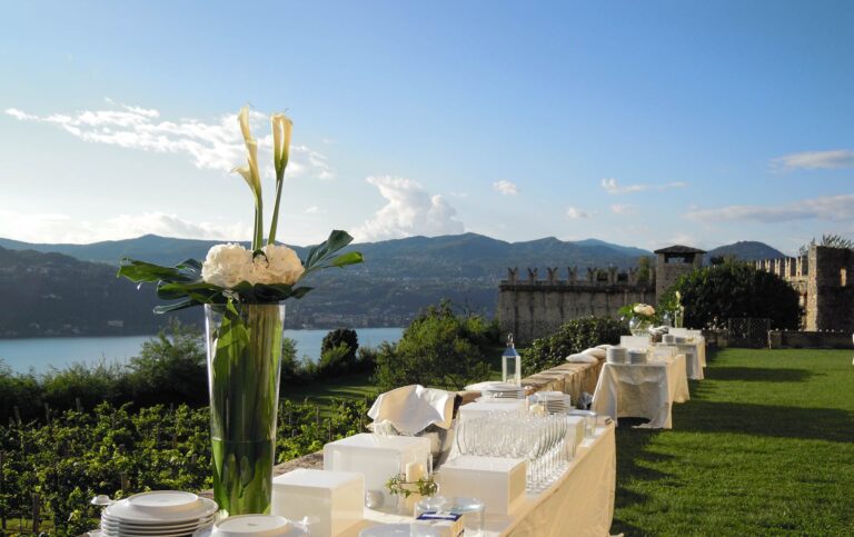 A buffet table with calla lilies on the castle lawn at the Rocca di Angera, Lake Maggiore below, Italian Wedding Company