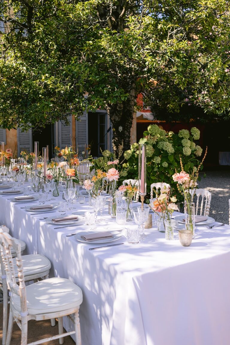 Long reception table under a lemon tree with tall flower stems, Italian Wedding