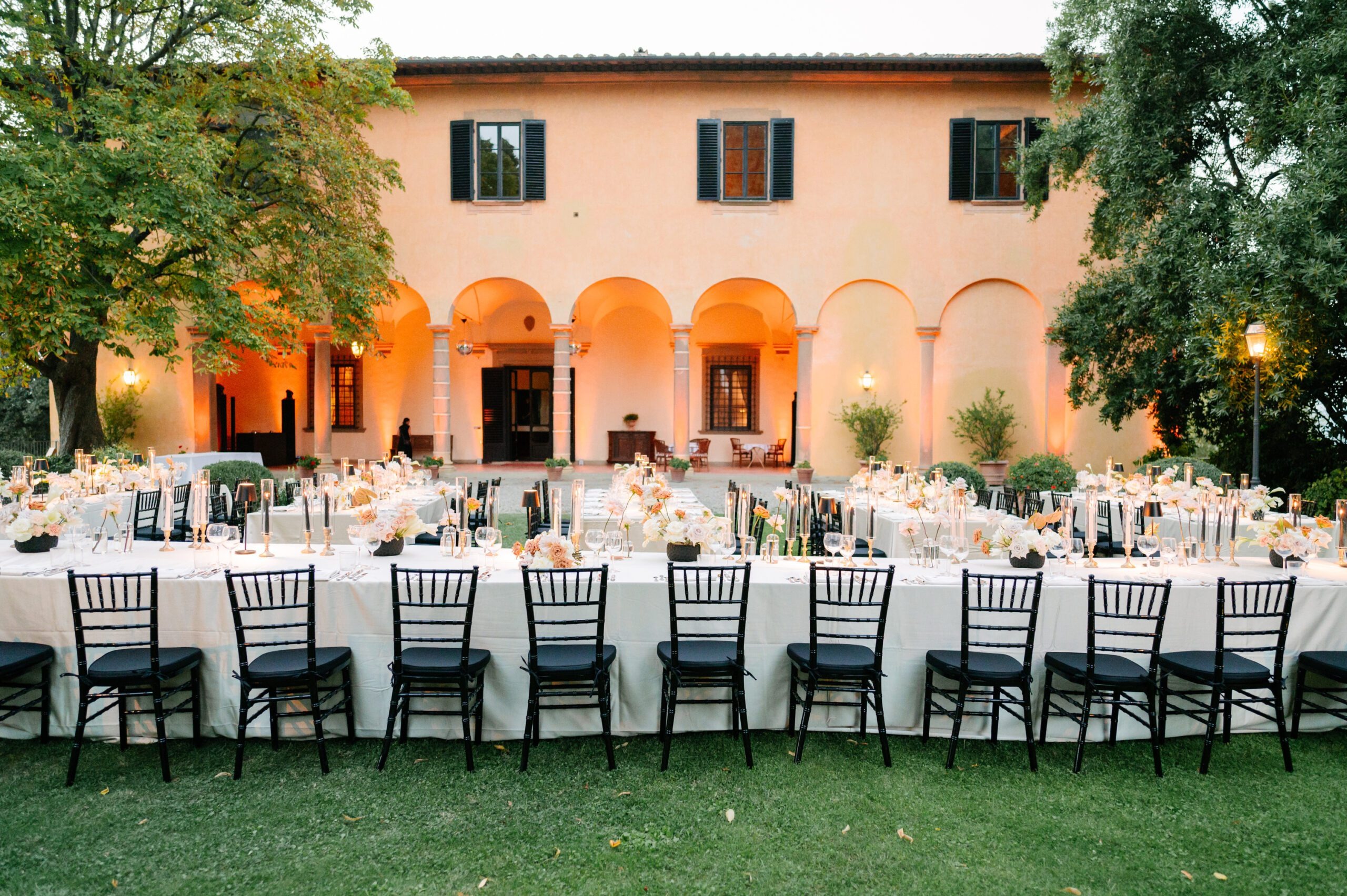 Villa Il Poggiale arcade with a long banquet table at dusk, Italian Wedding