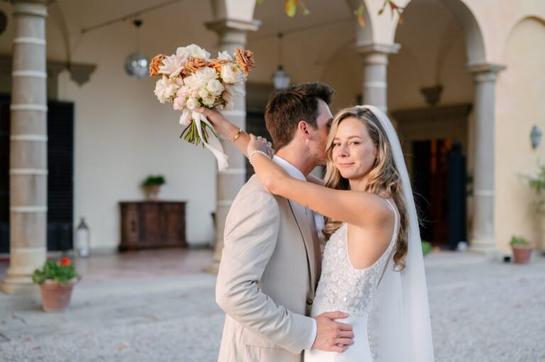 Couple embracing in a villa loggia with a bouquet, Italian Wedding