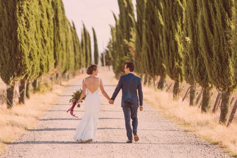 Couple walking a cypress-lined Tuscan road, Italian Wedding