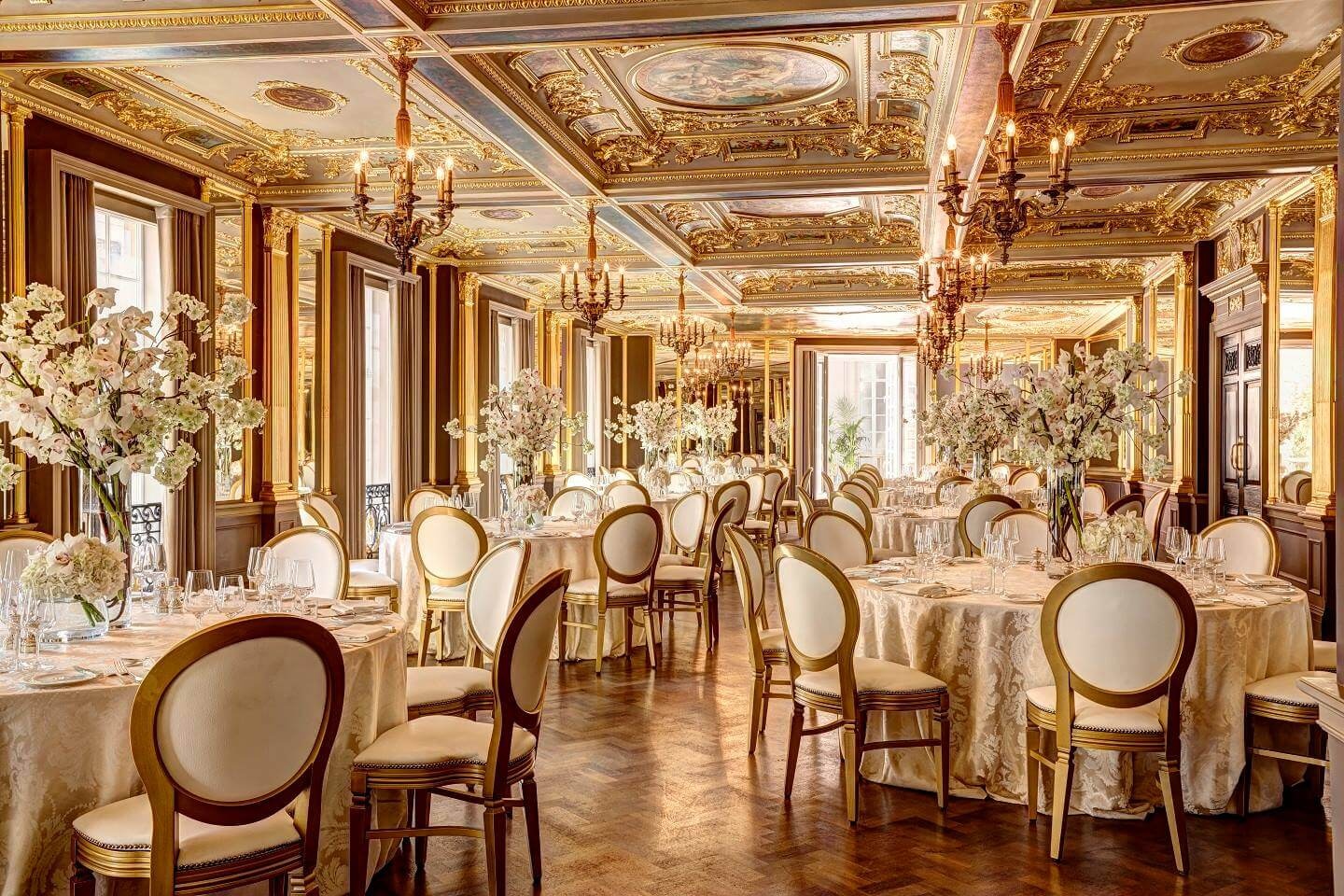 A gilded ballroom reception, cherry blossom and rose centrepieces on every table, Jamie Aston