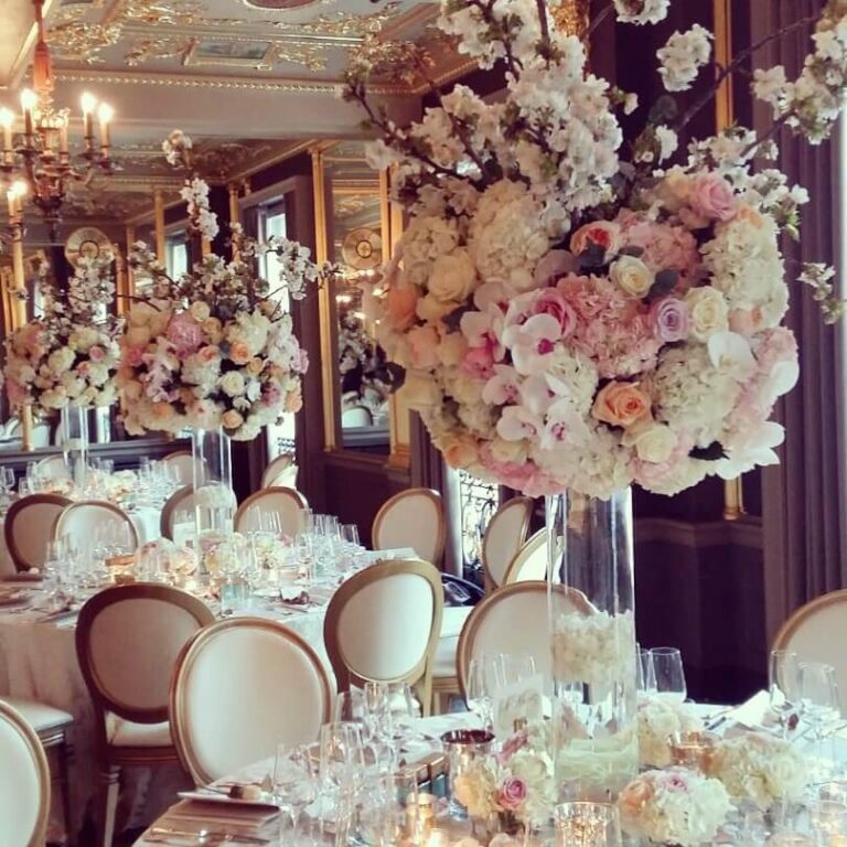 A tall centrepiece of cherry blossom, rose and orchid, mirrored in the ballroom's gilt walls, Jamie Aston