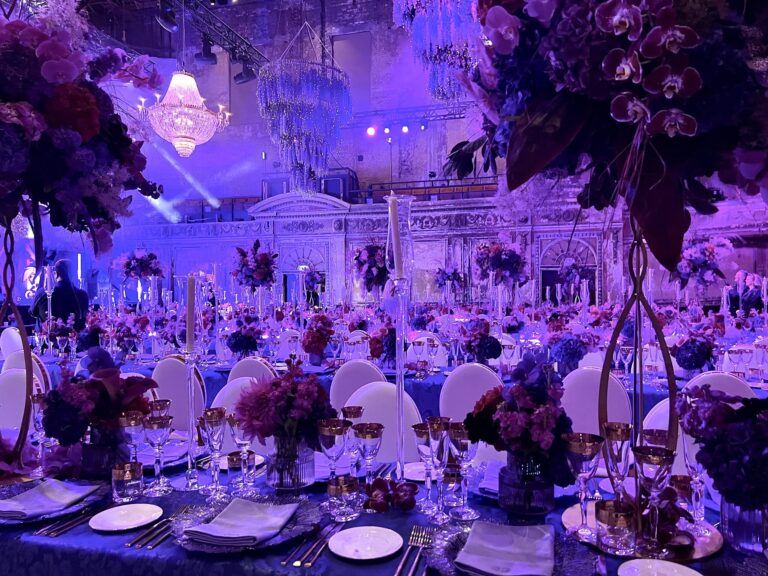 The finished installation glows purple over a candlelit reception, Jamie Aston