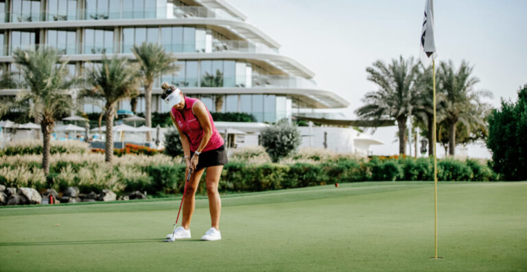 Putting on the green at the JA Golf Course with JA Lake View Hotel behind, Jebel Ali Golf Resort