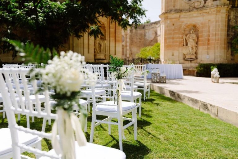 White ceremony chairs with floral posies in a walled Maltese garden, Jewelweddings Event Planners