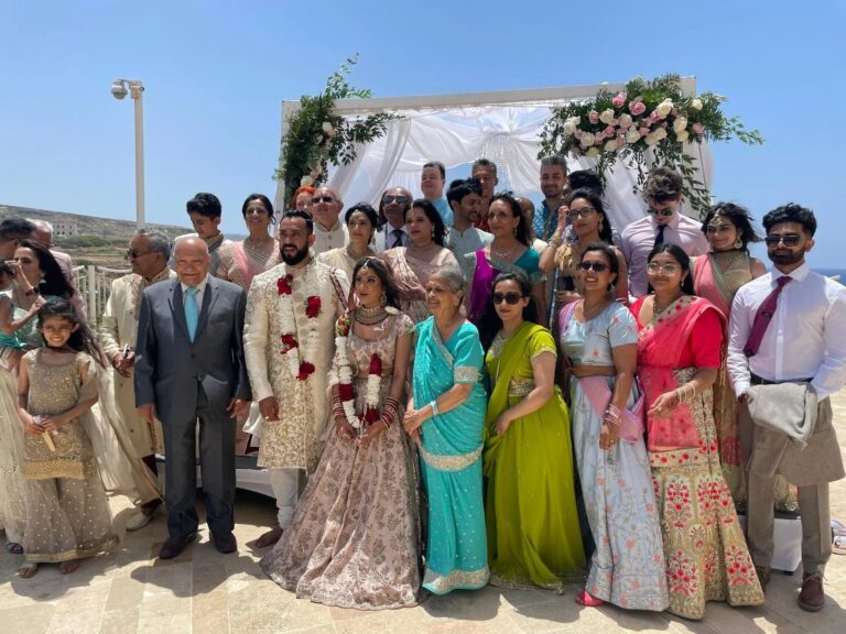 A family group beneath a floral mandap with the sea behind, Malta, Jewelweddings Event Planners