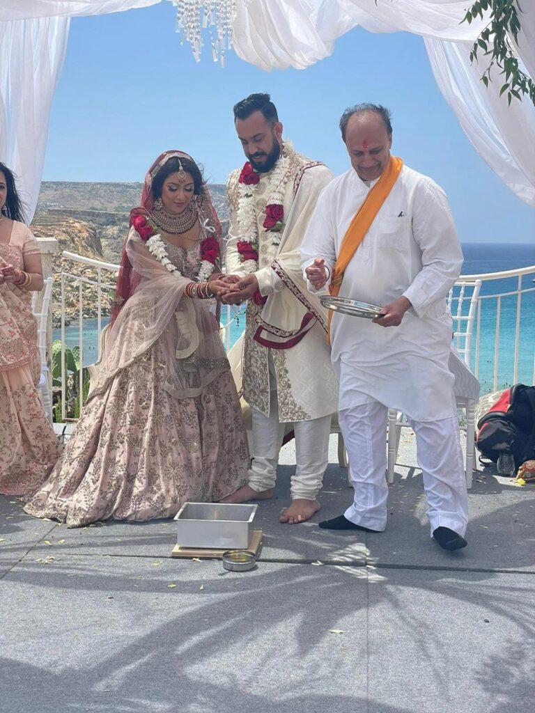 Hindu wedding rituals with garlanded couple on a terrace above the sea, Jewelweddings Event Planners