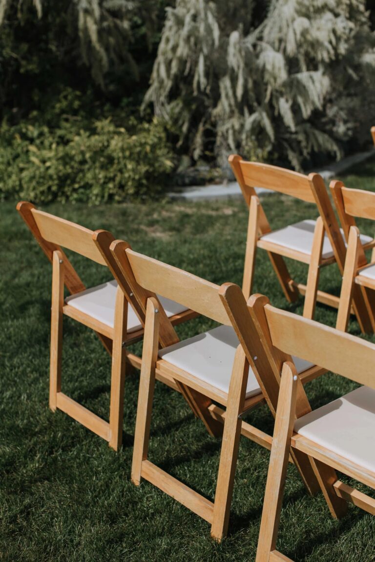 Wooden folding chairs set out on the lawn for a ceremony, Jewelweddings Event Planners
