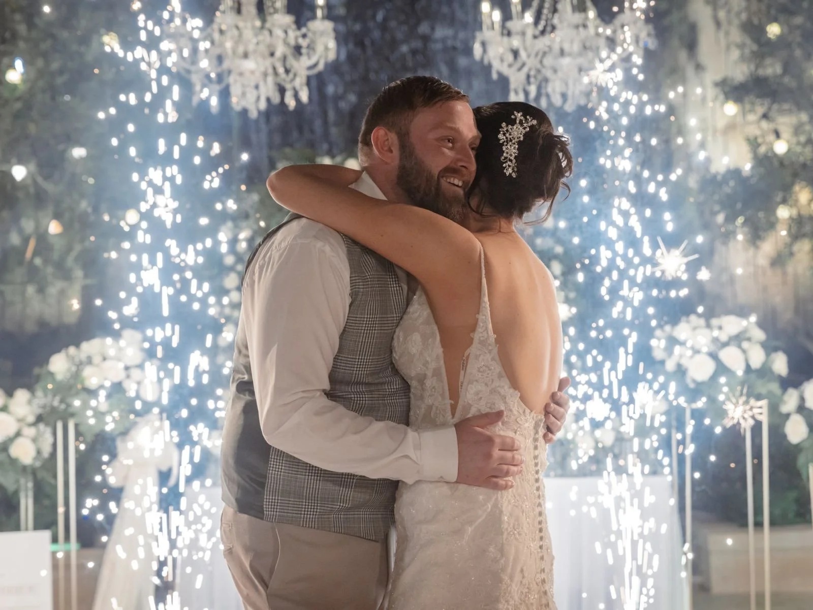 A first dance beneath chandeliers with sparkler fountains behind, Jewelweddings Event Planners