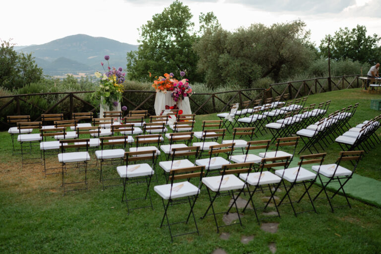 Ceremony seating laid out on the lawn at Nikis Resort, Umbria, with two flower plinths facing the valley, Joy Wedding
