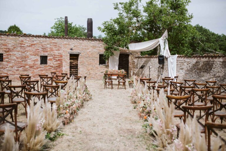 Courtyard ceremony at the Barco Ducale, Urbania, with pampas grass lining the aisle, Joy Wedding
