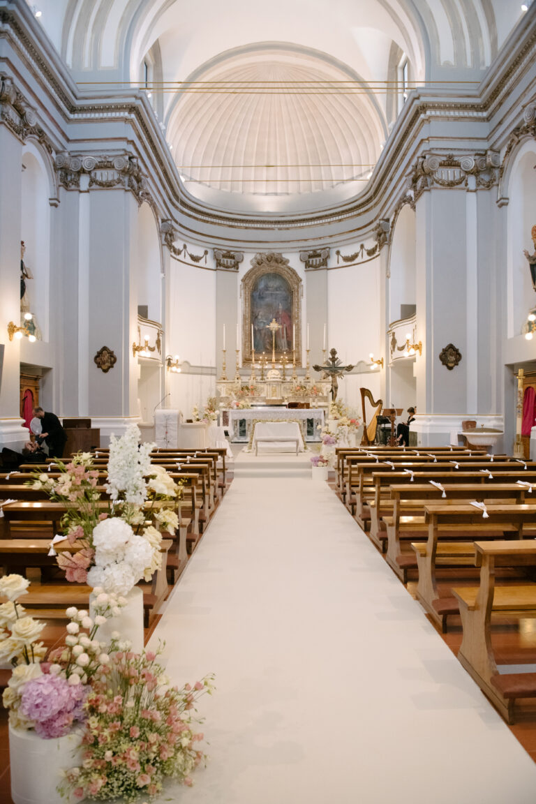 A church aisle dressed with white and blush flowers for an Italian-American wedding in Abruzzo, Joy Wedding