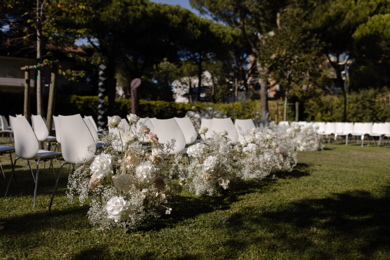 White flowers and gypsophila along the ceremony aisle in the garden of MarePineta Resort, Milano Marittima, Joy Wedding