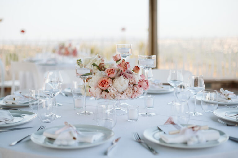 A round table with peach roses, glassware and folded menus at Tenuta Biodinamica Mara, Rimini, Joy Wedding