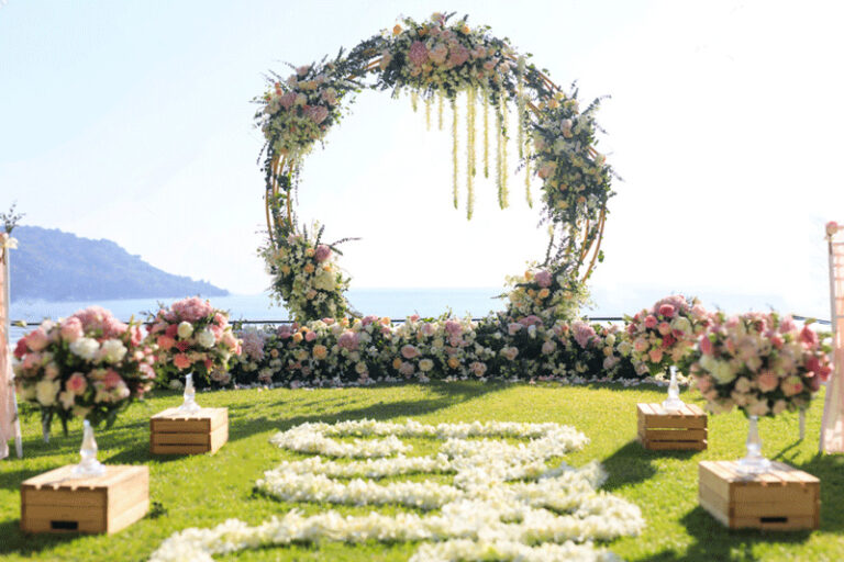 A floral ceremony arch on a lawn above the lake, Julia Event