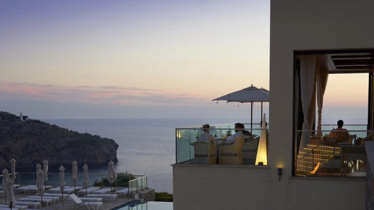 The clifftop pool deck and terrace at dusk, loungers set high above Port de Soller bay, Jumeirah Port Soller Hotel & Spa