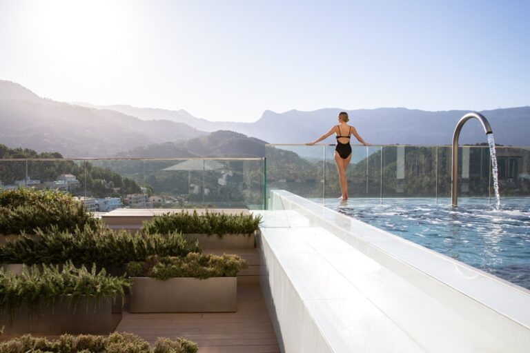 The infinity pool by day, a swimmer at the edge and the Serra de Tramuntana behind, Jumeirah Port Soller Hotel & Spa