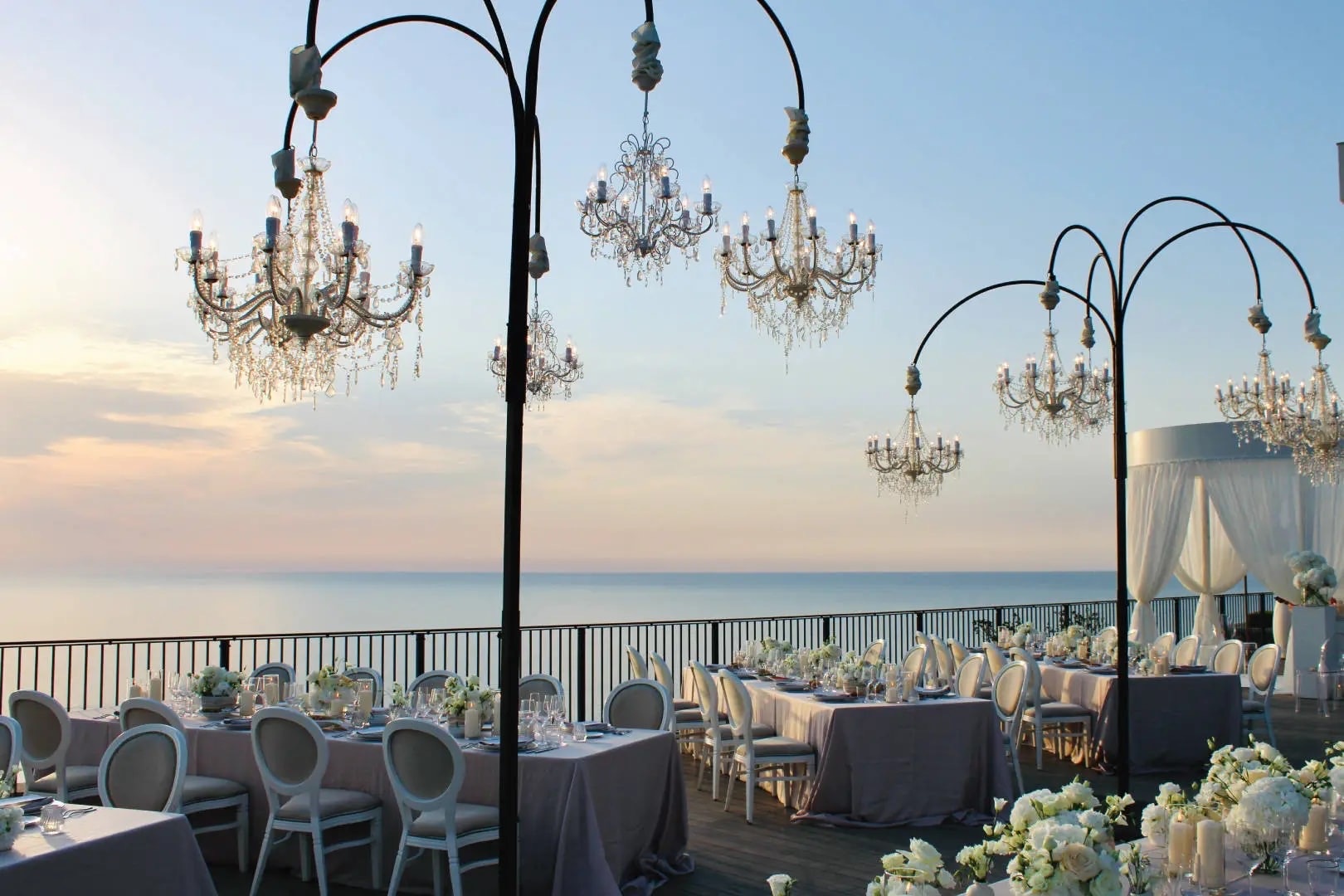 A wedding terrace at dusk, chandeliers hung above a long table laid over the sea, Jumeirah Port Soller Hotel & Spa