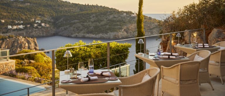 The Es Fanals terrace at dusk, tables set above the cove, Jumeirah Port Soller Hotel & Spa