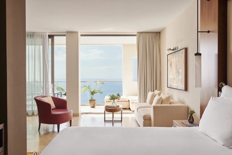 A suite living room framing the Mediterranean through full-height glass, Jumeirah Port Soller Hotel & Spa