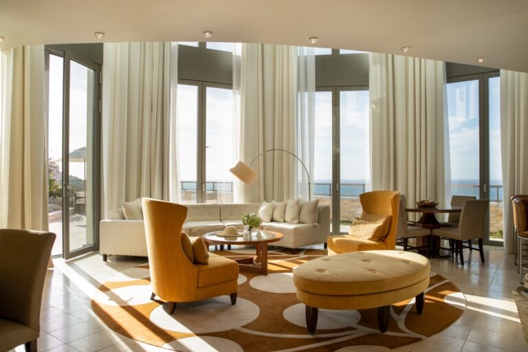 A suite lounge with tan armchairs and floor-to-ceiling windows, Jumeirah Port Soller Hotel & Spa