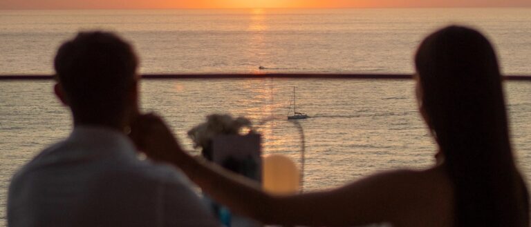 A couple at golden hour, the sea and a sailing boat below, Jumeirah Port Soller Hotel & Spa