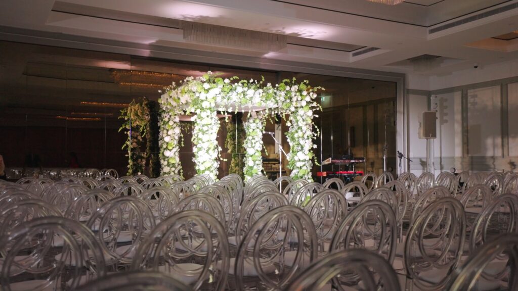 Floral chuppah set ahead of the ceremony with clear chairs in rows, Just Smile Ltd