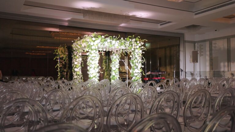 Floral chuppah set ahead of the ceremony with clear chairs in rows, Just Smile Ltd