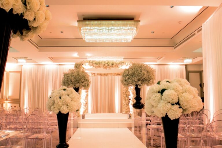 Ceremony aisle lined with white hydrangea arrangements and a draped canopy, Just Smile Ltd