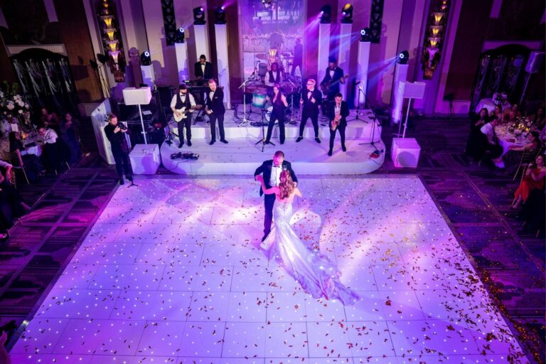 First dance on a lit white dance floor with the band on stage behind, Just Smile Ltd