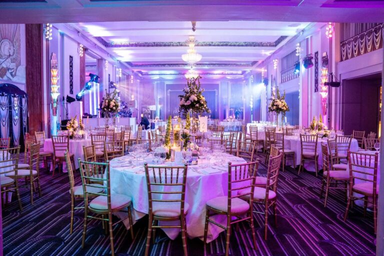 Banqueting room with round tables, uplighting and chandeliers, Just Smile Ltd