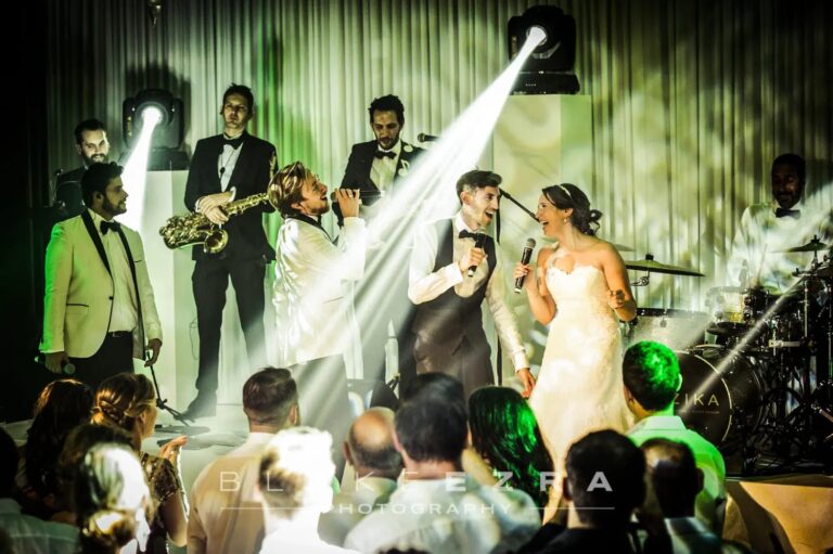 Live band and bride on a lit stage with spotlights and haze, Just Smile Ltd