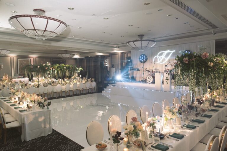 Long banquet tables beside a white dance floor under moving head lighting, Just Smile Ltd