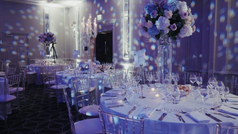 Round table settings with tall floral centrepieces and gobo-lit walls, Just Smile Ltd