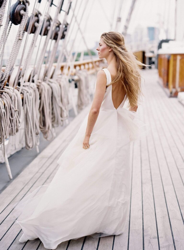 A low back gown with a long skirt on the deck of a tall ship, Kate Edmondson Bridal Couture