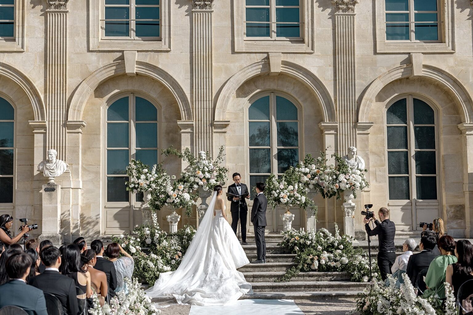 A ceremony in front of the Château de Chantilly, guests seated on the lawn