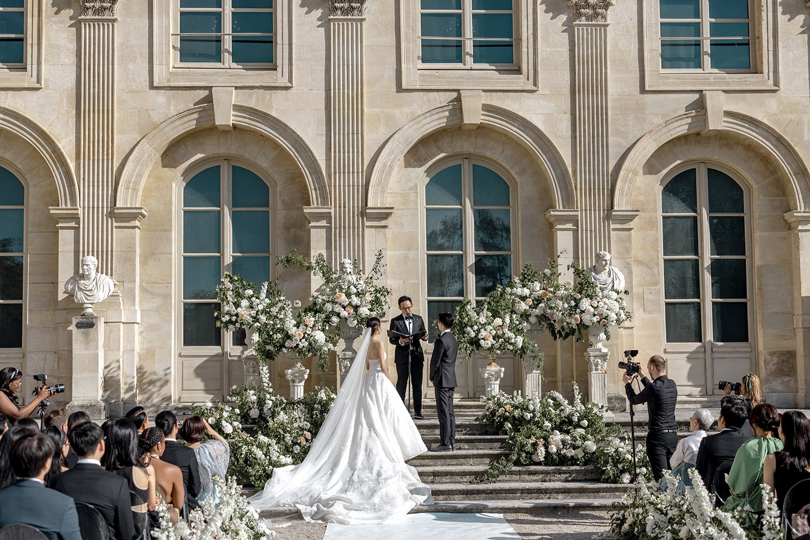 Ceremony in front of the Château de Chantilly, guests seated on the lawn, Katerina Meyvial Wedding & Event Planner