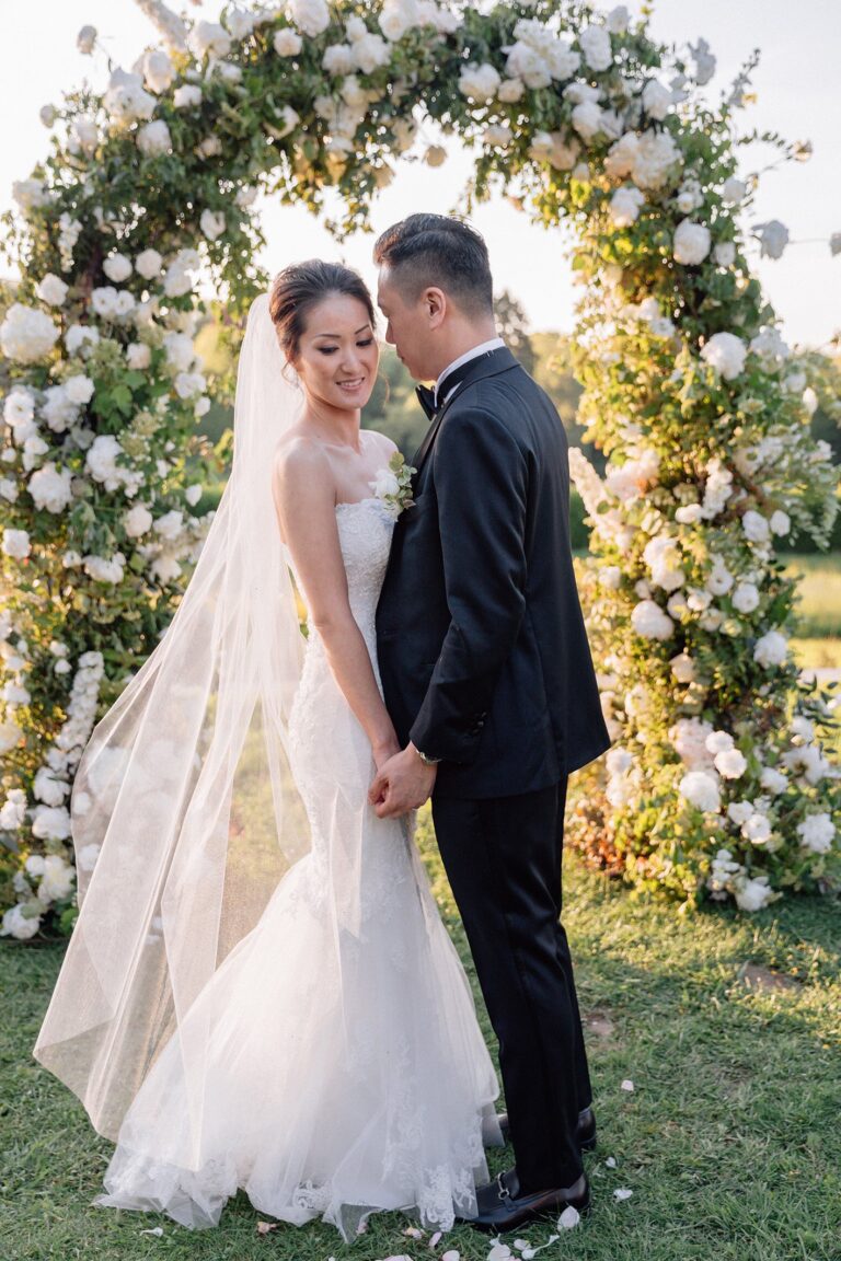 Elopement couple under a round arch of white and green flowers in a garden, Katerina Meyvial Wedding & Event Planner