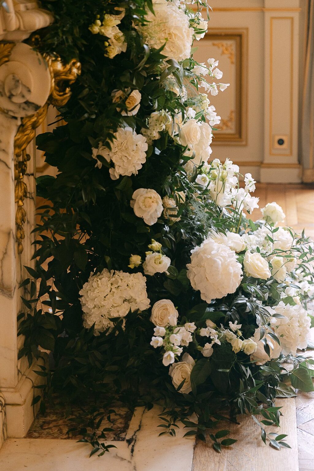 Tall white floral installation against gilded panelling, Katerina Meyvial Wedding & Event Planner