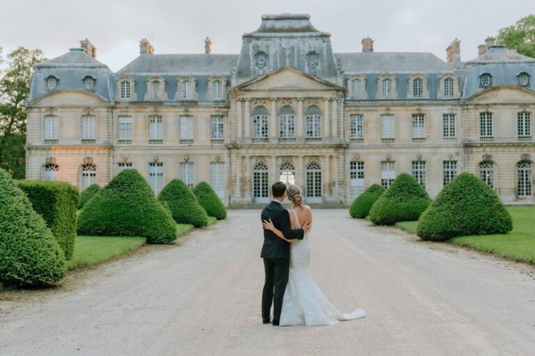 Couple embracing on the gravel forecourt of a château, Katerina Meyvial Wedding & Event Planner