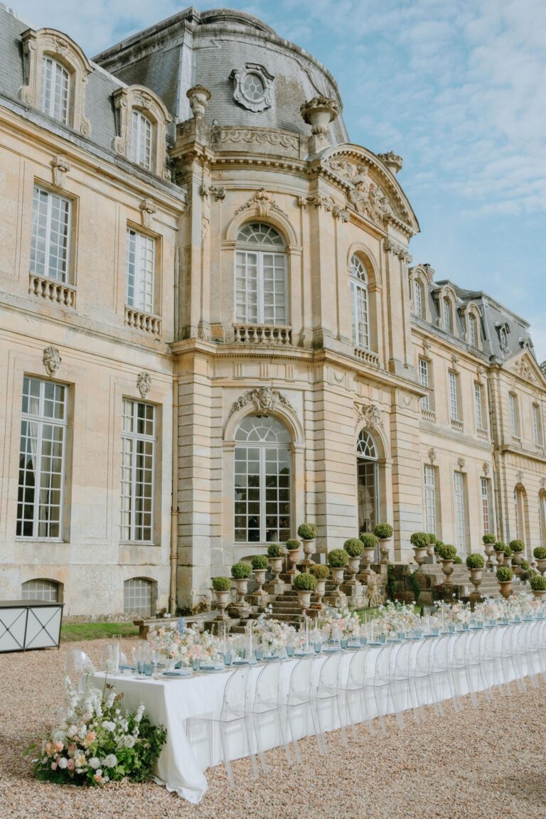 Long banquet table set along a château terrace in the sunshine, Katerina Meyvial Wedding & Event Planner