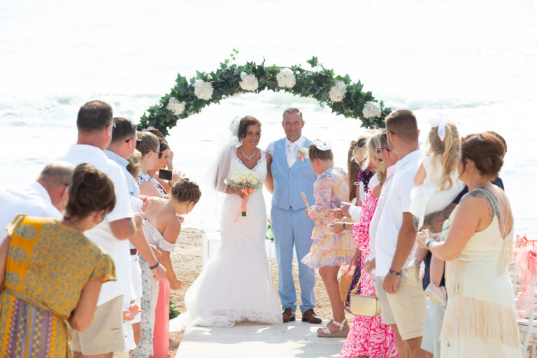 Wedding party under a floral arch on the beach, Kefalos Beach Weddings