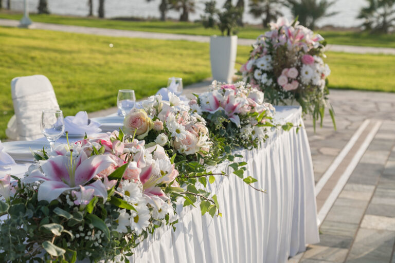 Top table with floral arrangements on the lawn, Kefalos Beach Weddings