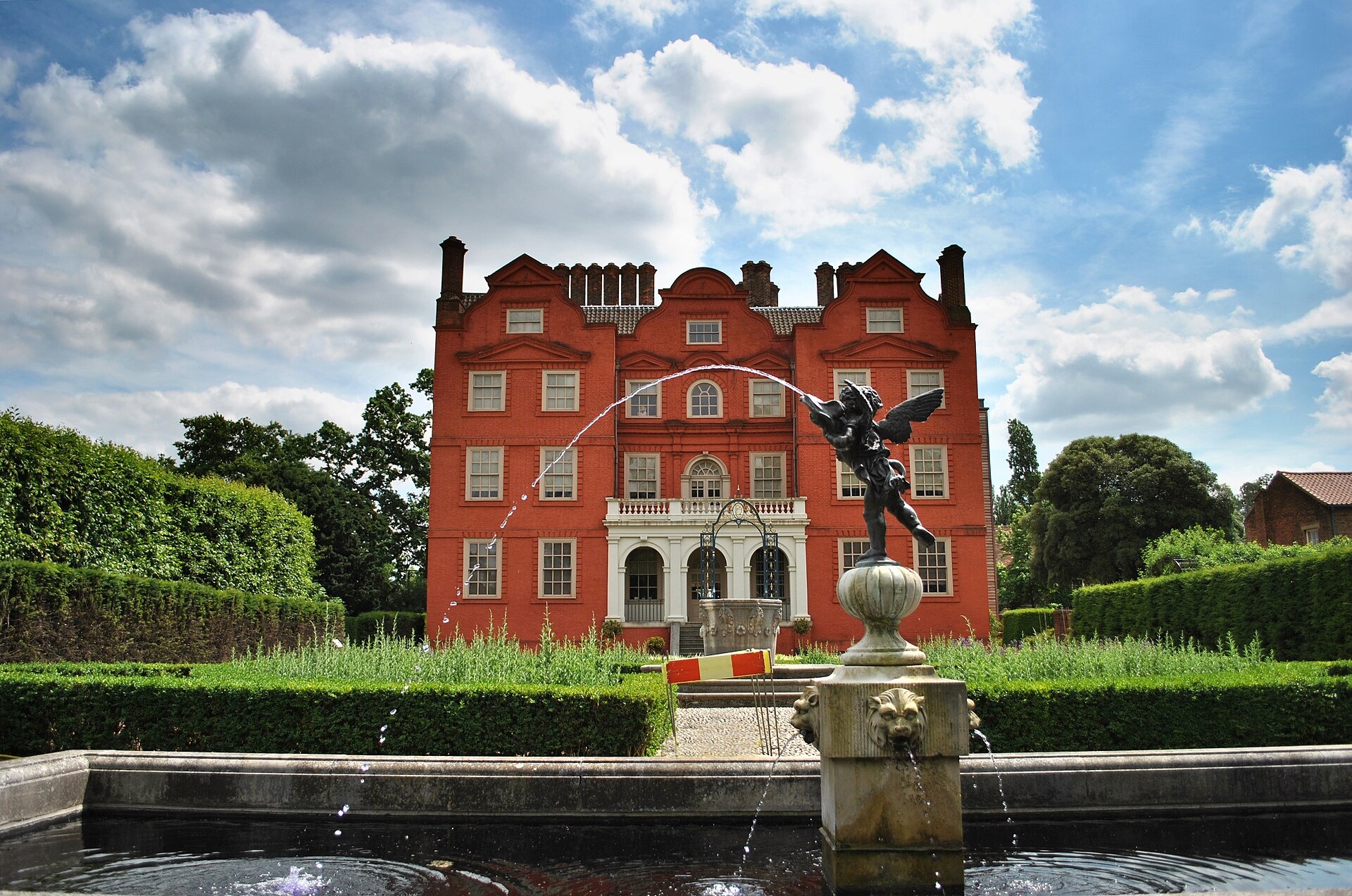 The Queen's Garden fountain playing before the red-brick palace, a gilded winged figure catching the light, Kew Palace