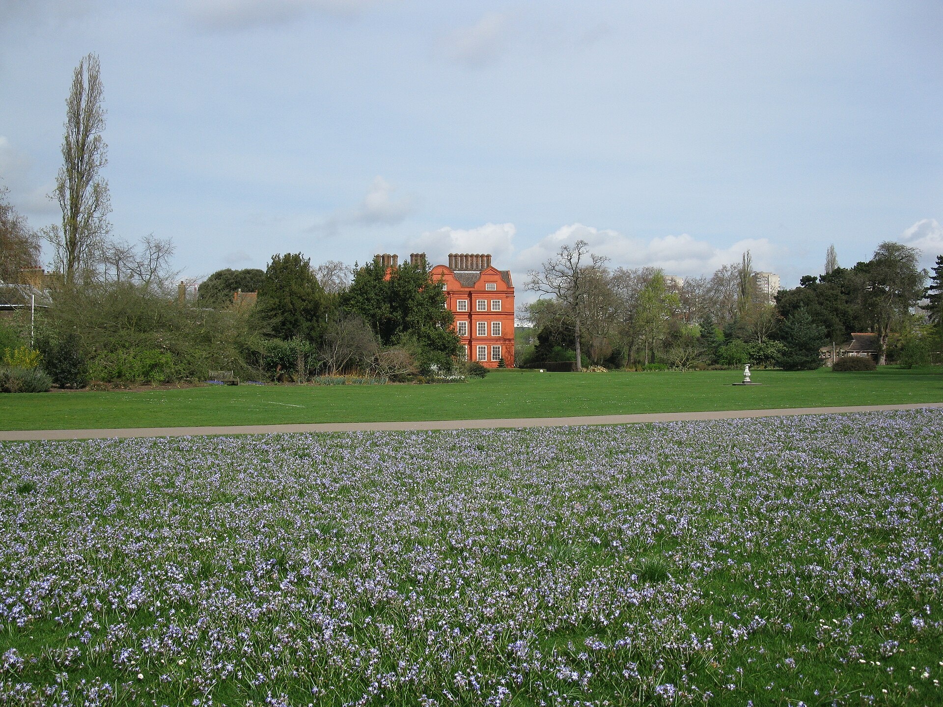 The palace across a spring meadow of blue chionodoxa within the Royal Botanic Gardens, Kew Palace