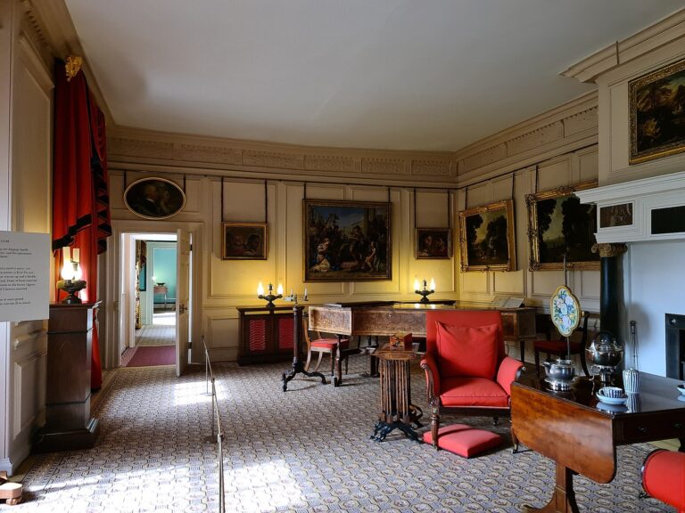 The Queen's Drawing Room, oak panelling hung with old master paintings and a fireside chair, Kew Palace