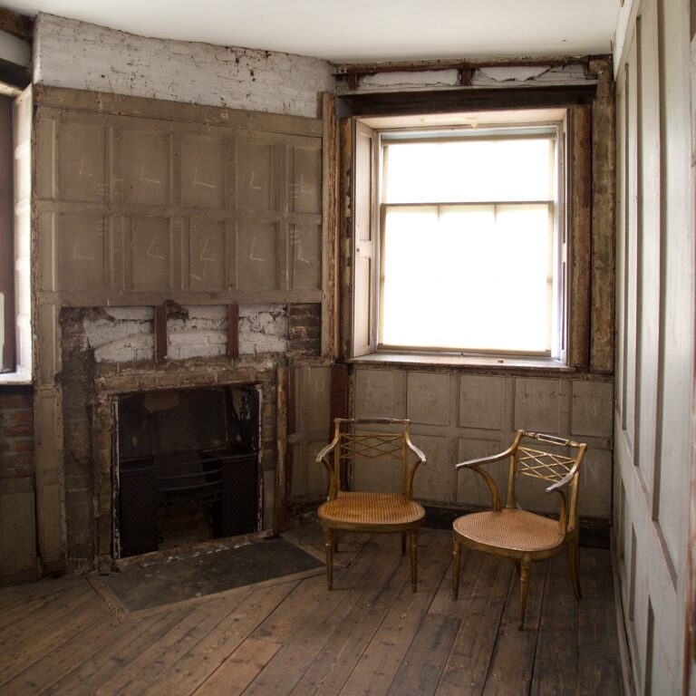 An oak-panelled chamber, a gilt-framed portrait above the marble chimneypiece, Kew Palace