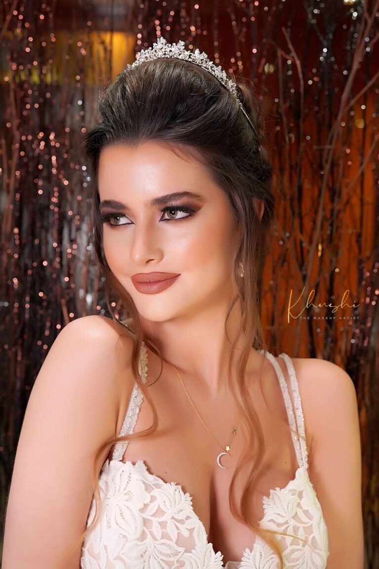 An ivory lace gown, loose curls, string lights behind, Khushi The Makeup Artist