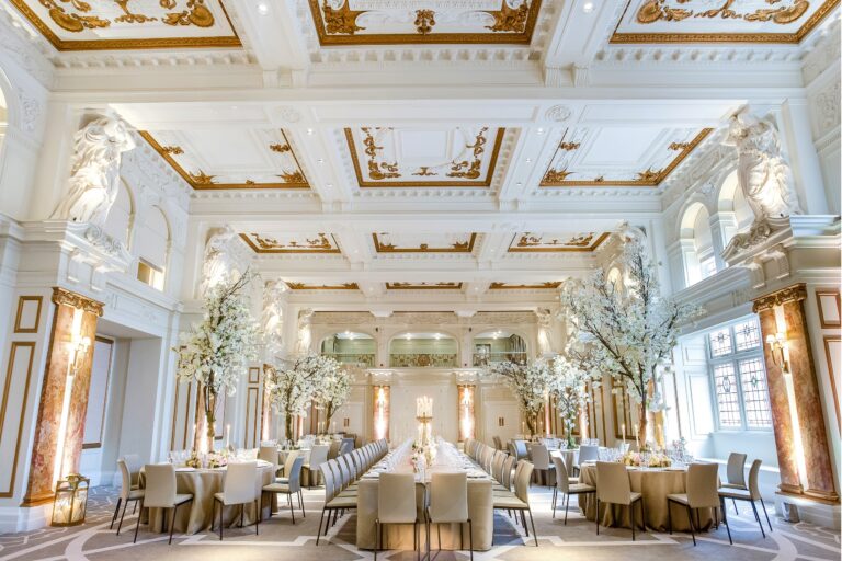 A full Ballroom set-up seen from the gallery end, with blossom-tree centrepieces and the windows along one side, Kimpton Fitzroy London